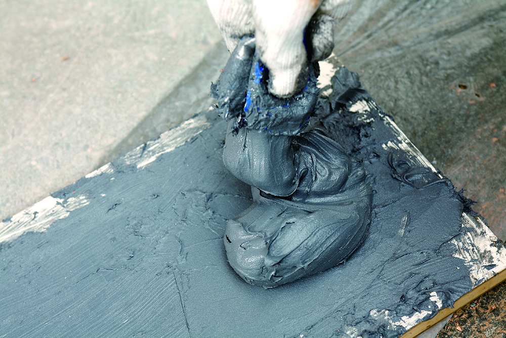 บีบกาวซีเมนต์ลงบนถาดเหล็ก โดยตัดปลายหลอดด้วยคัตเตอร์ กาวจะไหลออกมา ให้บีบไปด้วยจะทำให้ไม่เลอะเทอะ