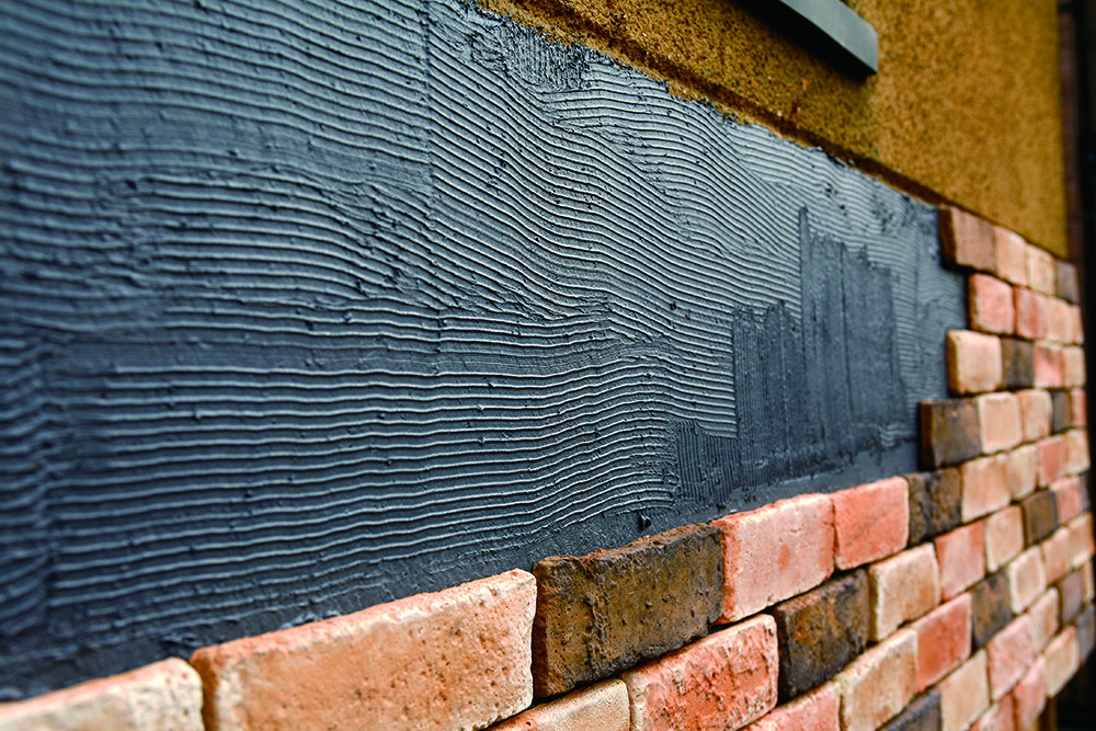 ปูกระเบื้องลงบนพื้นผิวที่ทากาวซีเมนต์ เริ่มเห็นระยะห่างระหว่างกระเบื้องลายอิฐ กรณีที่เว้นระยะมากไป สามารถแก้ไขได้ในช่วงนี้ (ควรเว้นระยะระหว่างกระเบื้องประมาณ 10 มม.)