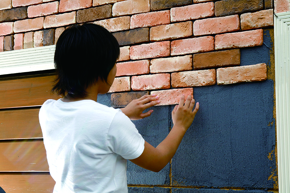 ปูและกดด้วยมือไปด้วย พยายามให้กาวติดกับพื้นผิวด้านล่างและตัวกระเบื้องลายอิฐในปริมาณที่เท่ากัน