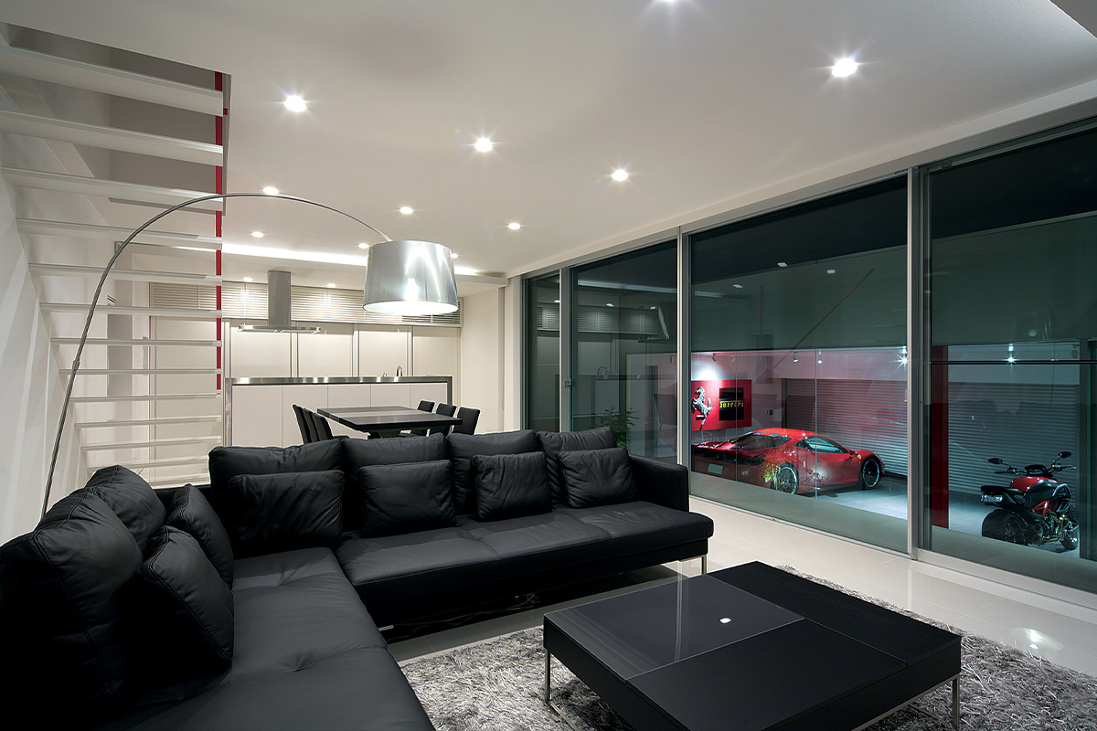 สามารถมองเห็นโรงจอดรถที่อยู่คนละหลังกับตัวบ้าน โดยมีพื้นที่ว่างคั่นกลาง เมื่อมองผ่านกระจกบานใหญ่ทั้งบานทำให้โรงจอดรถดูเหมือน Gallery รถเหล่านี้ดูจากมุมไหนก็เหมือนภาพวาด ทั้งมุมเฉียงจากด้านหลัง แต่จะดูสวยที่สุดถ้ามองจากตำแหน่งที่สูงหน่อย ภาพที่เห็นนี้เป็นการออกแบบที่ผ่านการวางแผนมาอย่างดี