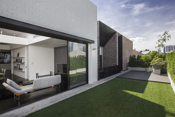 ลบความแตกต่างของบ้านเดิมกับบ้านใหม่ด้วยการกรุผนังภายนอกด้วยอิฐมอญ กลมกลืนด้วยระเบียงทางเชื่อมระหว่างห้องนอนกับโรงจอดรถ