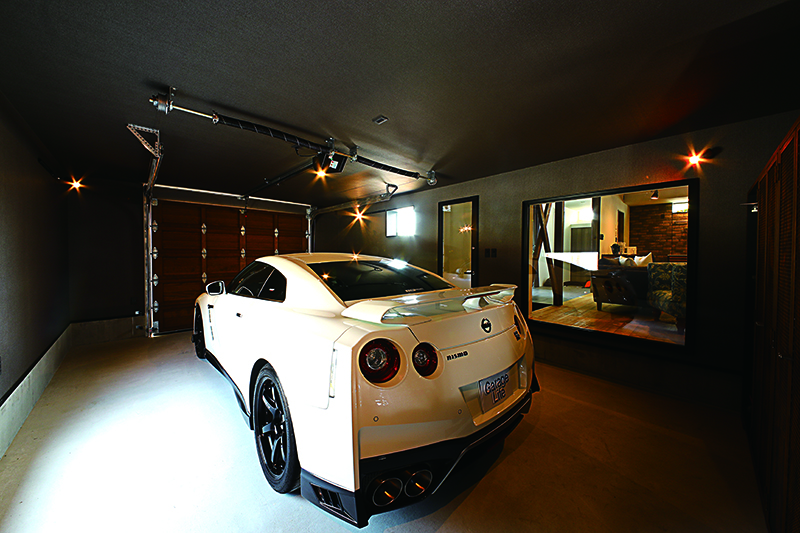 โรงจอดรถแบบบิลท์อินมีขนาดพอสำหรับการจอดรถหนึ่งคันอย่างสบายๆ นอกจากจะติดตั้งหน้าต่างกระจกบานใหญ่กั้นแบ่งโรงจอดรถกับห้องนั่งเล่นไว้แล้ว ยังติดประตูสำหรับเข้าออกไว้ด้วย