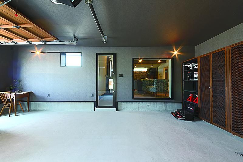 ส่วนผนังและเพดานภายในของโรงจอดรถใช้แผ่นปิดผนังแบบเดียวกันทั้งหมด ด้านหน้าทางขวาของรูปจะเห็นว่ามีประตูเชื่อมต่อติดตั้งอยู่ด้านในสุดของโรงจอดรถ ทำให้สามารถเข้าไปนั่งเล่นภายในบ้านได้