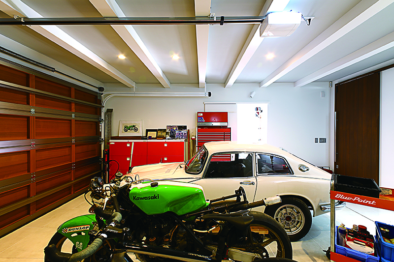 พอเปิดประตู WOOD FLAT HB DOOR ขนาดกว้าง 5,350 มิลิเมตร ก็พบกับพื้นที่จอด Honda S800 Coupe ที่ได้มาอยู่ในมือเมื่อประมาณ 20 ปีที่แล้ว ส่วนด้านหน้าเป็น Kawasaki KR250 Works Racer ที่กลับมาจากฝรั่งเศส 