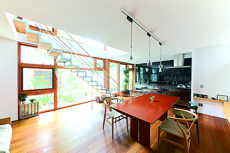 ที่ห้องนั่งเล่น สั่งครัวแบบ Kitchen Island ของ TOYO KITCHEN ภรรยาของคุณยุกุจิตัดสินใจเลือกจากการไปดูนิทรรศการมาหลายแห่ง ครัวมีฟังก์ชันสเปกสูง ซึ่งกลายเป็นของตกแต่งภายในไปโดยอัตโนมัติ ผนังเป็นสีชาร์โคล