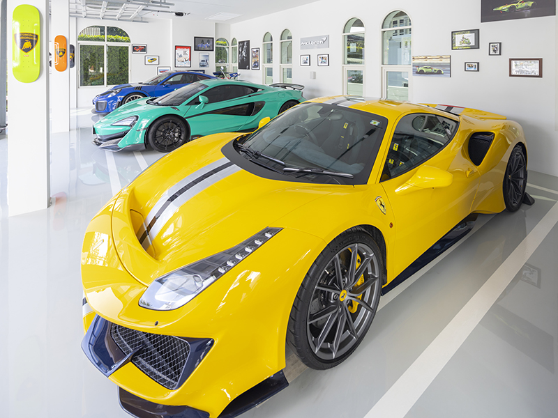 ผนังโรงจอดรถทาสีขาวและตกแต่งด้วยภาพที่เพื่อนๆ มอบให้ MR.LEE วันที่สร้างโรงจอดรถเสร็จทำให้ซูเปอร์คาร์ทั้ง 3 คันที่จอดอยู่ ดูโดดเด่นมาก โดยเฉพาะ Ferrari 488 Pista เครื่องยนต์ V8 Bi-turbo 3,902 ซี.ซี. 720 แรงม้า