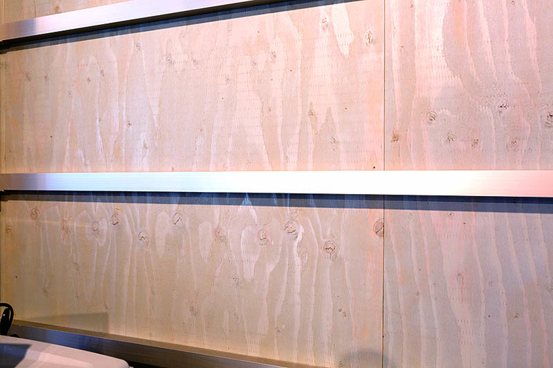 ผนังด้านในของโรงจอดรถใช้ผ้าสไตล์ RC ส่วนไม้อัดไม้ทาด้วย Xyladecor สีเทา ซึ่งมีคุณสมบัติกันแมลงและเชื้อรา