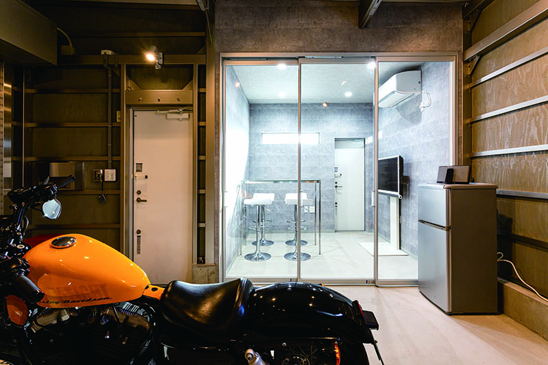 แบ่งโซนห้องอ่านหนังสือกับโรงจอดรถโดยใช้ฉากกั้น (Screen Partition) แบบแขวนของ YKK AP เนื่องจากมีเครื่องปรับอากาศสำหรับพื้นที่ 50 ตร.ม. ในห้องอ่านหนังสือ จึงสามารถทำให้ภายในโรงจอดรถเย็นสบาย