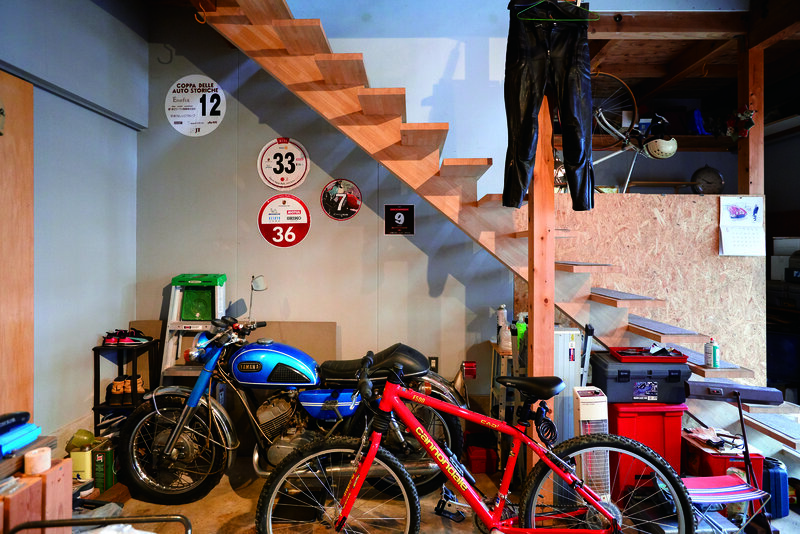 ภายในโรงจอดรถซึ่งมีโต๊ะทำงานอยู่ด้วย ทำหน้าที่เป็นพื้นที่เก็บของที่เกี่ยวข้องกับกีฬาทางน้ำและเหล่ารถคันโปรด ขณะเดียวกัน ก็ยังเป็นพื้นที่สำหรับซ่อมยบำรุงรถ 2 ล้อและ 4 ล้ออีกด้วย