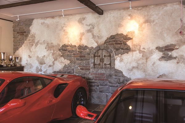 คอนเซ็ปต์ของโรงจอดรถคือ โรงนาร้างในชนบทของอิตาลี ผนังจึงทำด้วยปูนเพื่อให้ได้รูปลักษณ์แบบโบราณ ประดับประดาด้วยรถขนาดเล็กในธีมเฟอร์รารีที่ซื้อมาและรถขนาดเล็กสีเดียวกับรถคันโปรดที่มอบให้กับผู้เข้าร่วม Ferrari Challenge 