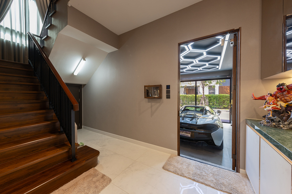 ประตูทางเชื่อมระหว่างตัวบ้านกับโรงจอดรถ ด้านข้างเป็นบันไดที่เชื่อมต่อไปยังชั้น 2 ของบ้าน